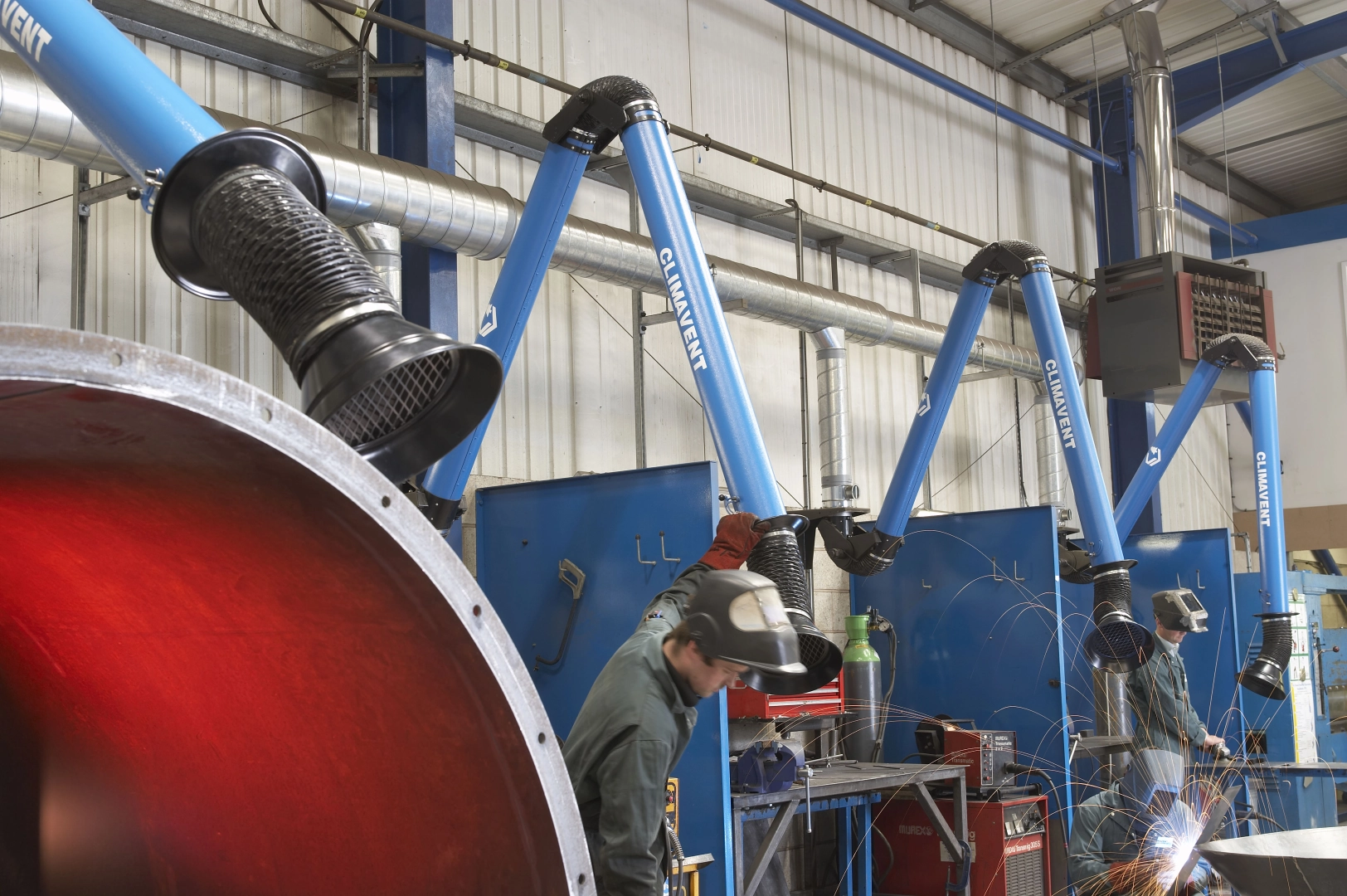 Welding fume extraction arms being used in a factory environment, connected onto a local fume extraction system