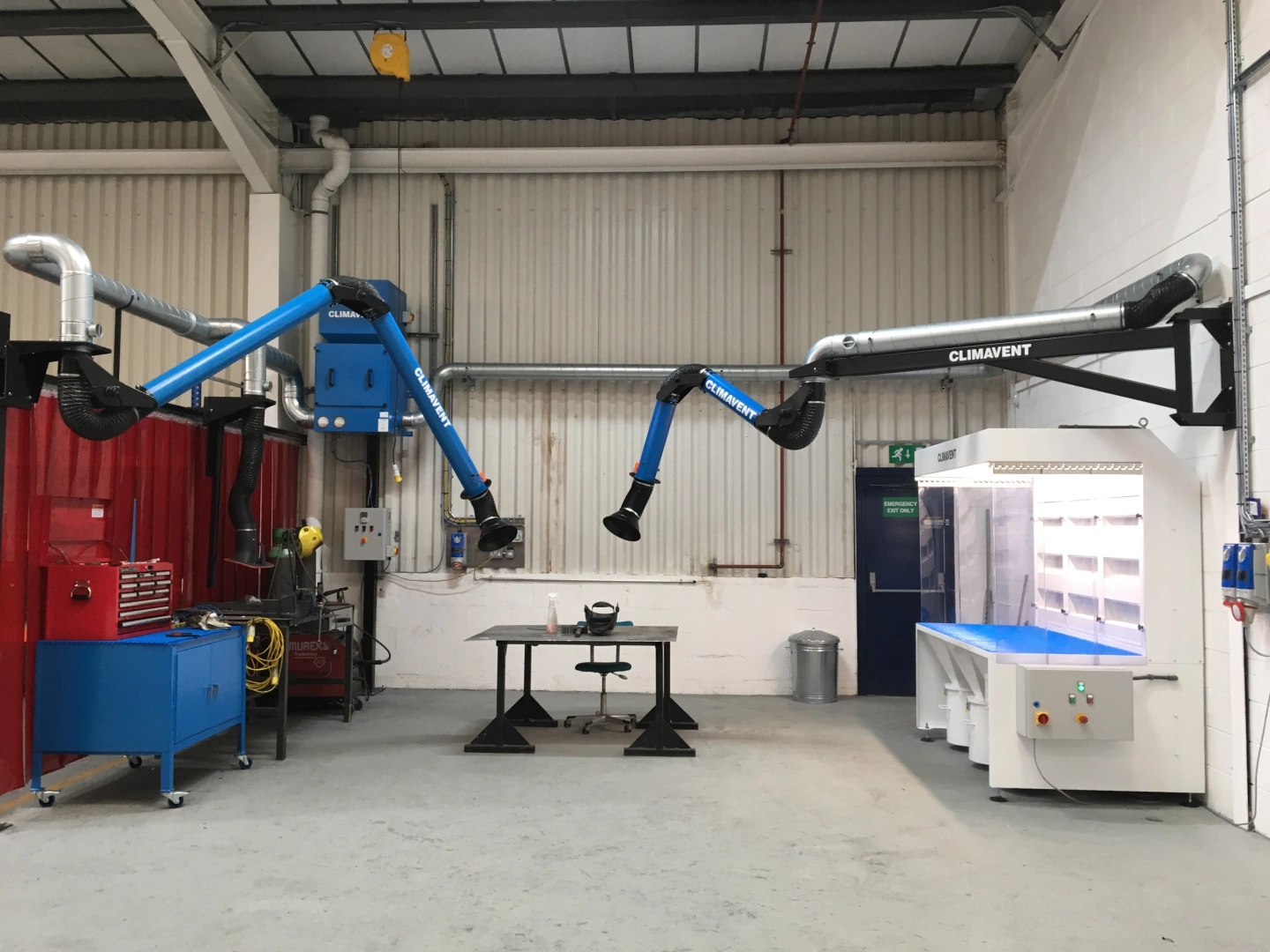 Extraction arms connected to a local extraction unit, sited using booms and stanchions over a bench during dust and fume applications